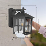 Black outdoor wall light fixture with dimensions being measured against a wall.