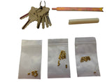 A lock pick kit displayed on a white background, including a set of keys, a metal tool, a cylindrical piece, and three small zippered bags containing brass-colored lock components.