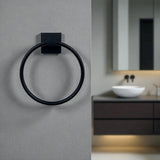 Black towel ring on a gray wall with a blurred bathroom background